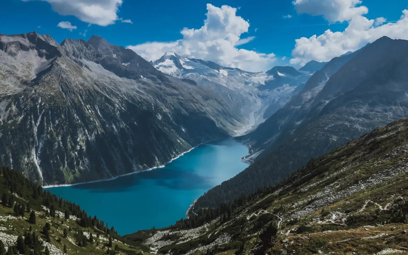 Logo de TEC intex, société d'import export, superposé sur un paysage de montagnes et de lac alpin